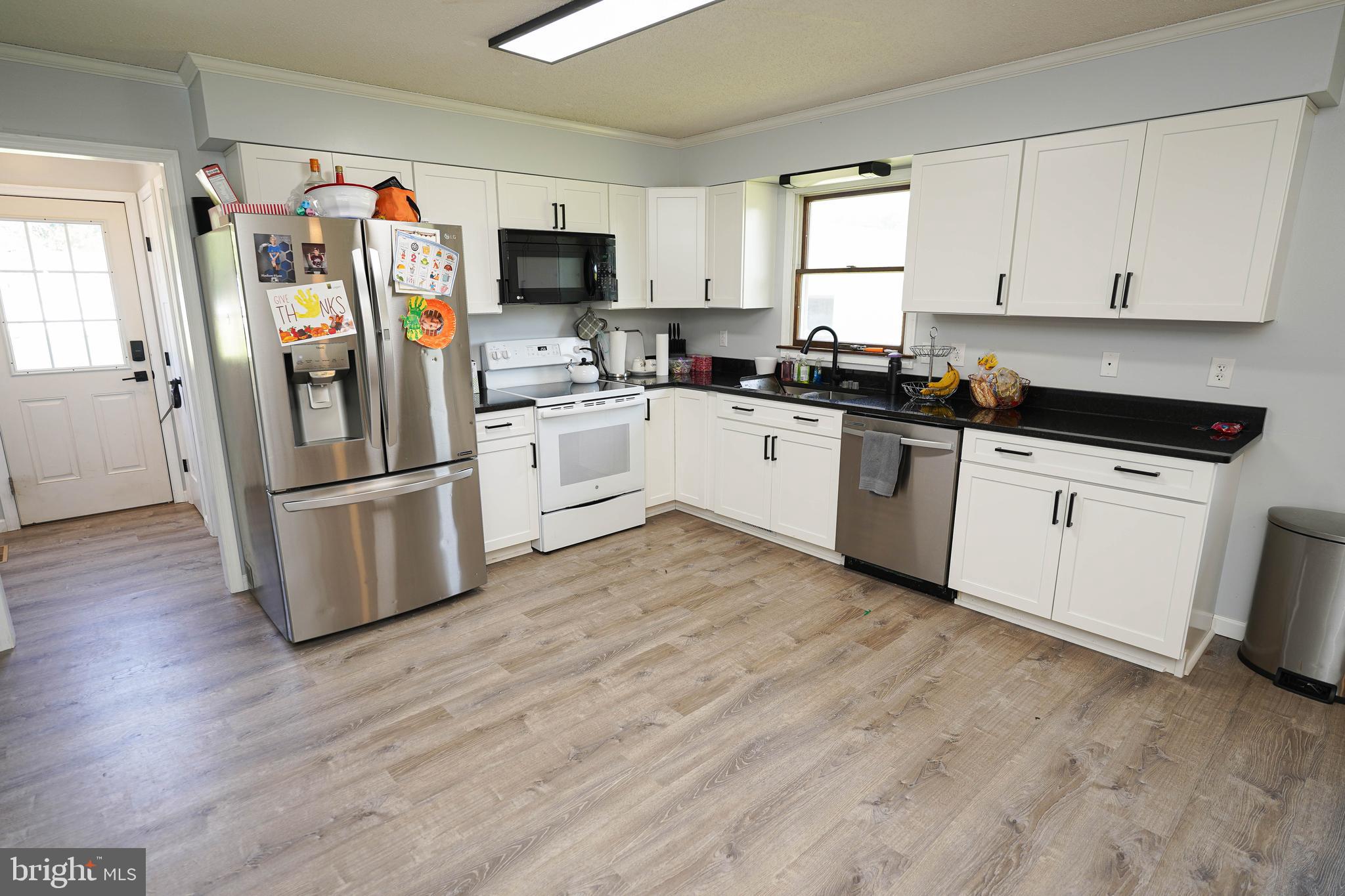 10564 Waller Road Laurel, DE 19956 - Photo 10 of 33 a kitchen with granite countertop a refrigerator and a stove top oven