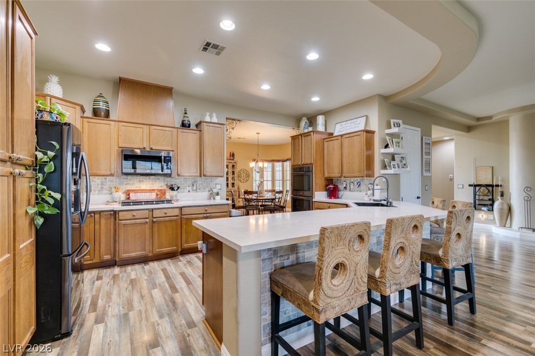 7524 Midnight Rambler Street Las Vegas, NV 89149 - Photo 20 of 51 Culinary delights await in this chef's kitchen, featuring warm wood cabinetry and a spacious central island.