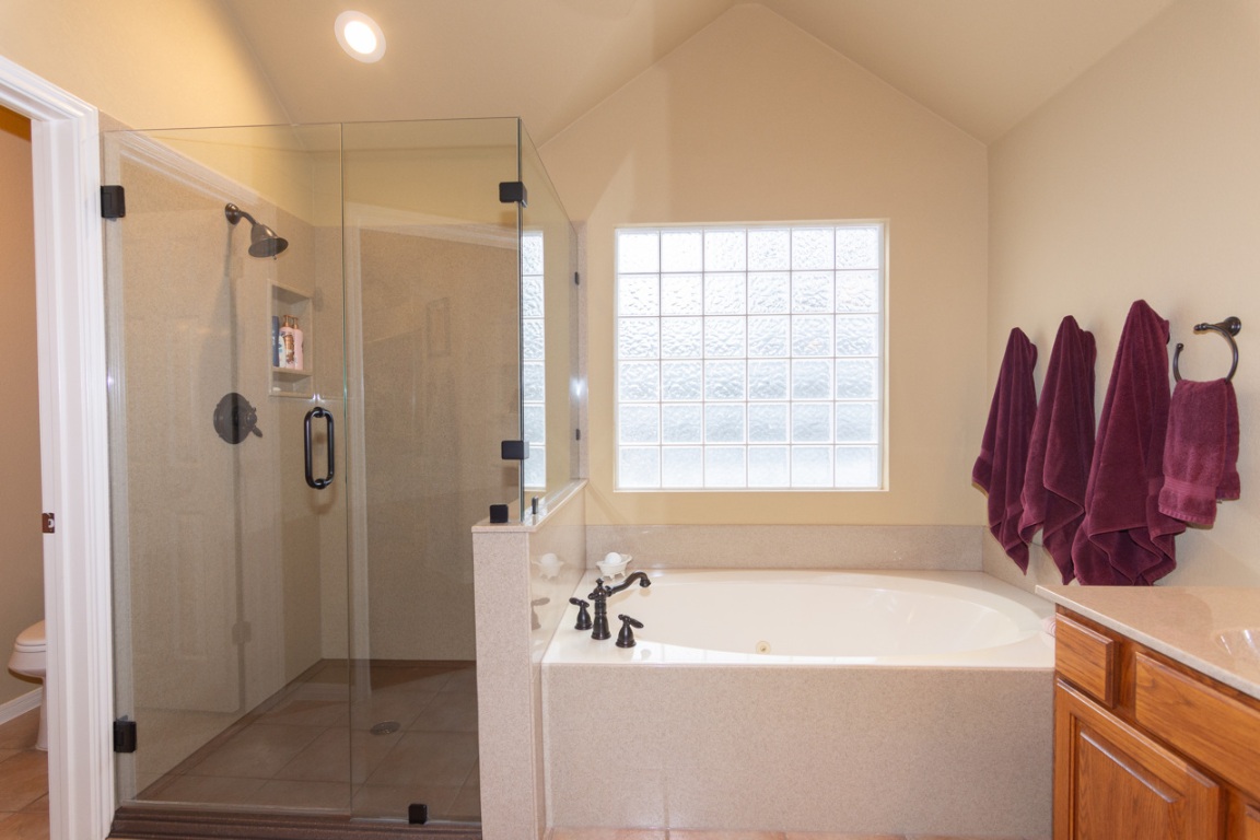 11401 Ohmfield Court Austin, TX 78739 - Photo 23 of 40 a bathroom with a tub a sink and a shower