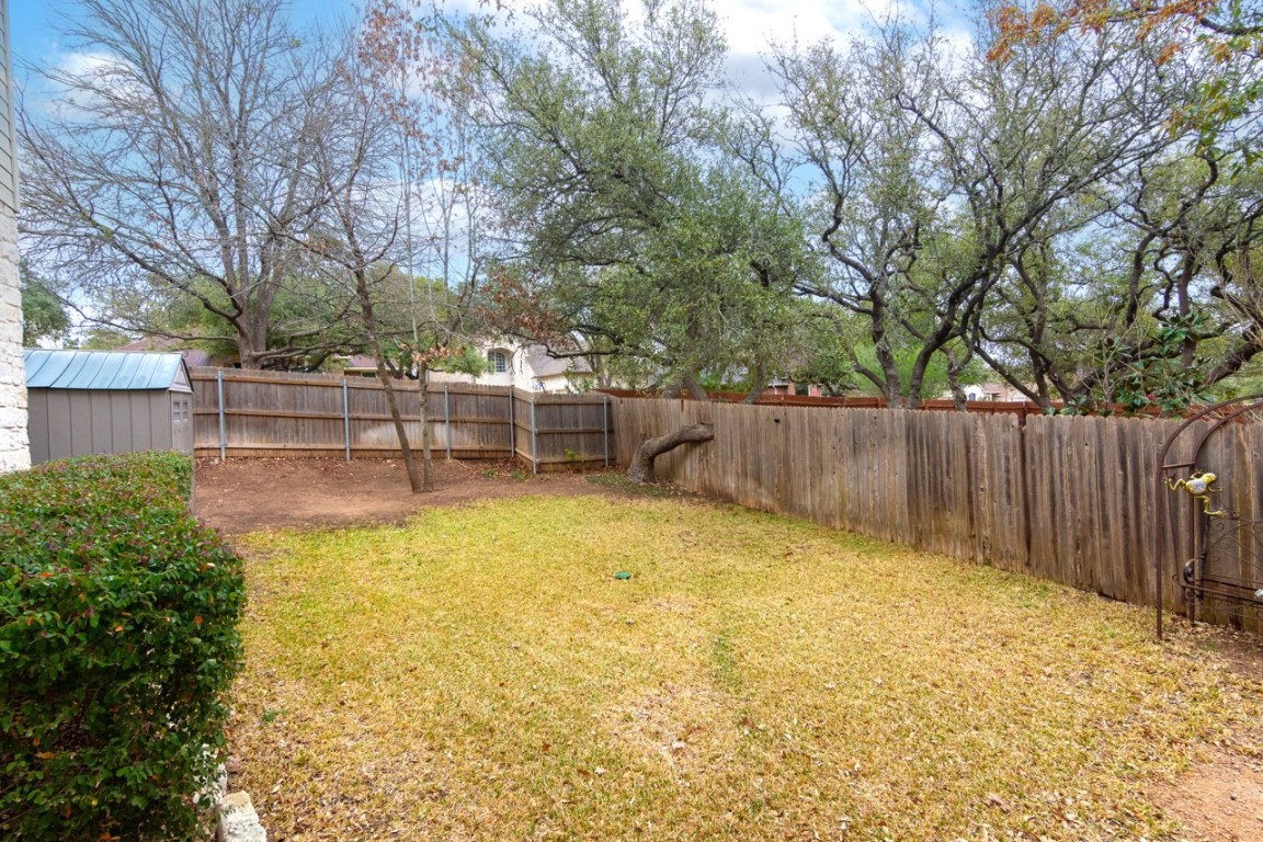 11401 Ohmfield Court Austin, TX 78739 - Photo 33 of 40 a view of a backyard with large trees and wooden fence