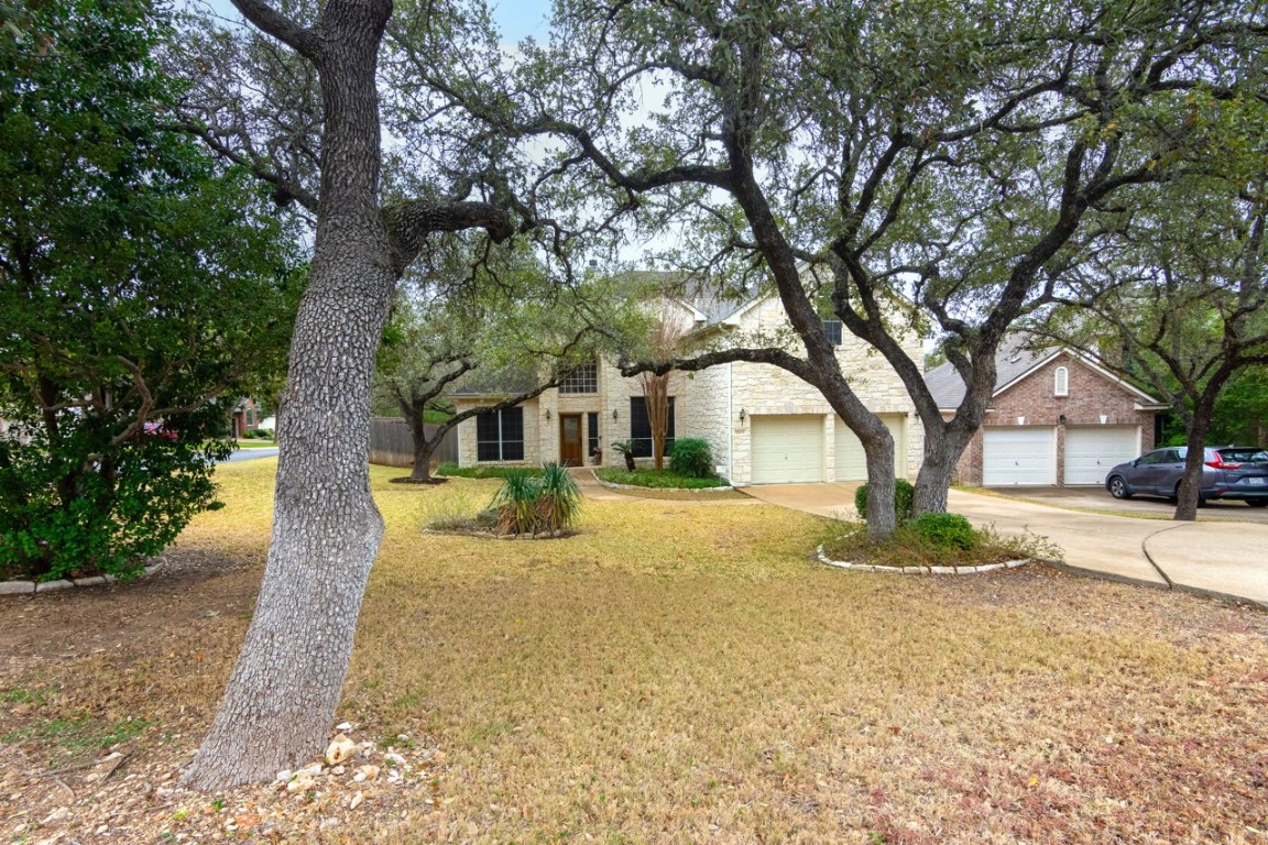 11401 Ohmfield Court Austin, TX 78739 - Photo 4 of 40 a front view of a house with a yard and large tree