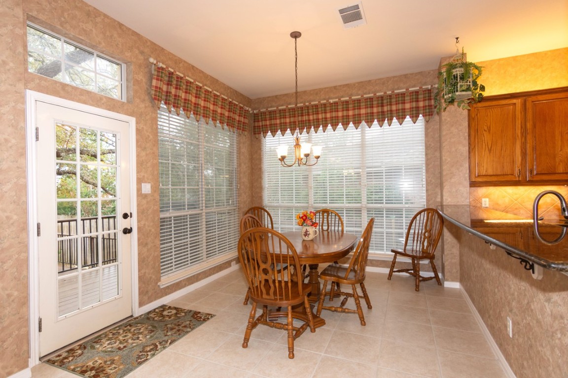 11401 Ohmfield Court Austin, TX 78739 - Photo 10 of 40 a dining room with furniture a chandelier and wooden floor