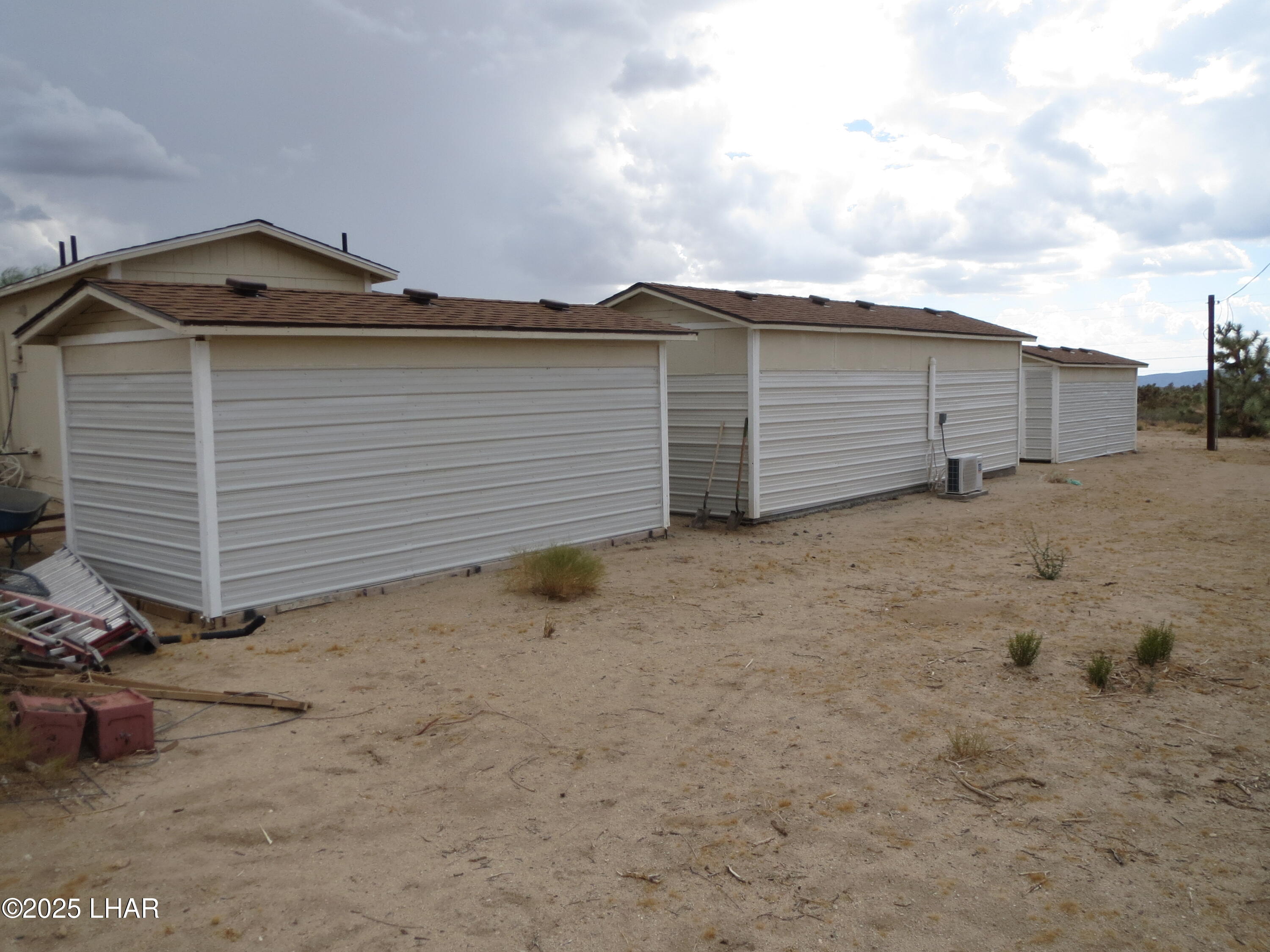 11964 Nolan Road Yucca, AZ 86438 - Photo 17 of 29 3 separate insulated storage buildings with truss roofs.