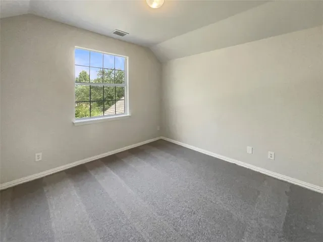 a view of a room that has wooden floor and a window