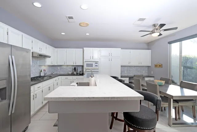 a kitchen with stainless steel appliances a sink a table and chairs