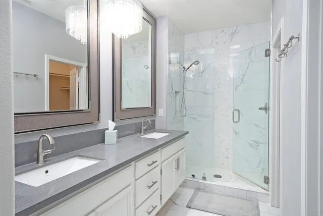 a bathroom with a double vanity sink mirror double and shower