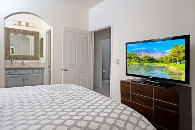 a bedroom with a bed and a flat screen tv