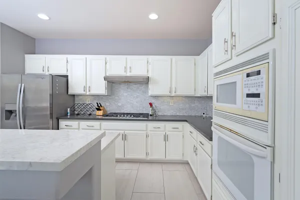 a kitchen with granite countertop a sink stainless steel appliances and cabinets