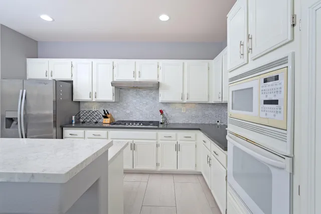 a kitchen with granite countertop a sink stainless steel appliances and cabinets
