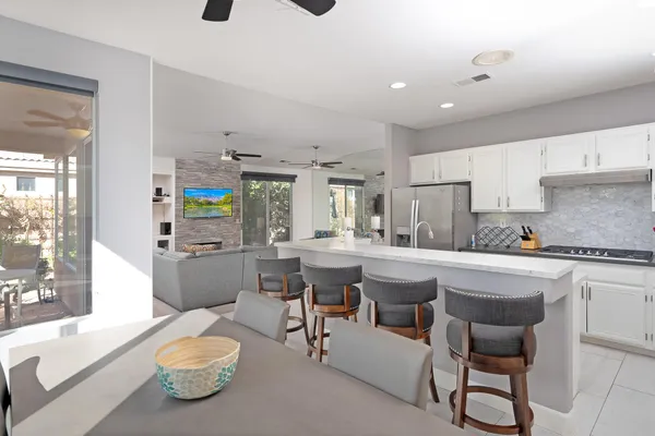 a kitchen with a sink and chairs