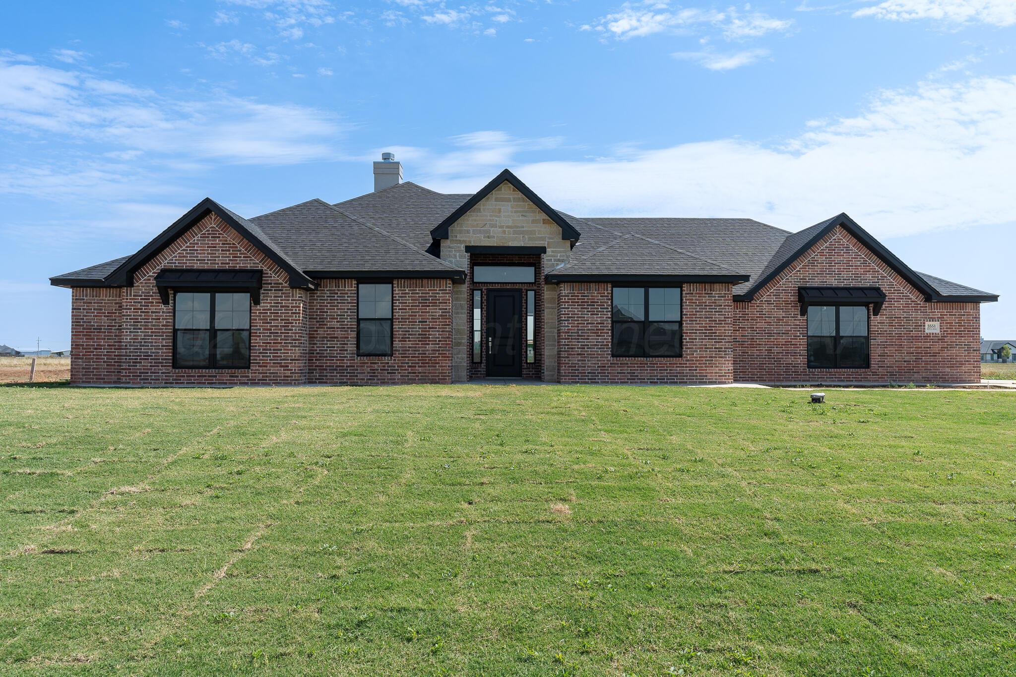a house with huge green field in front of it