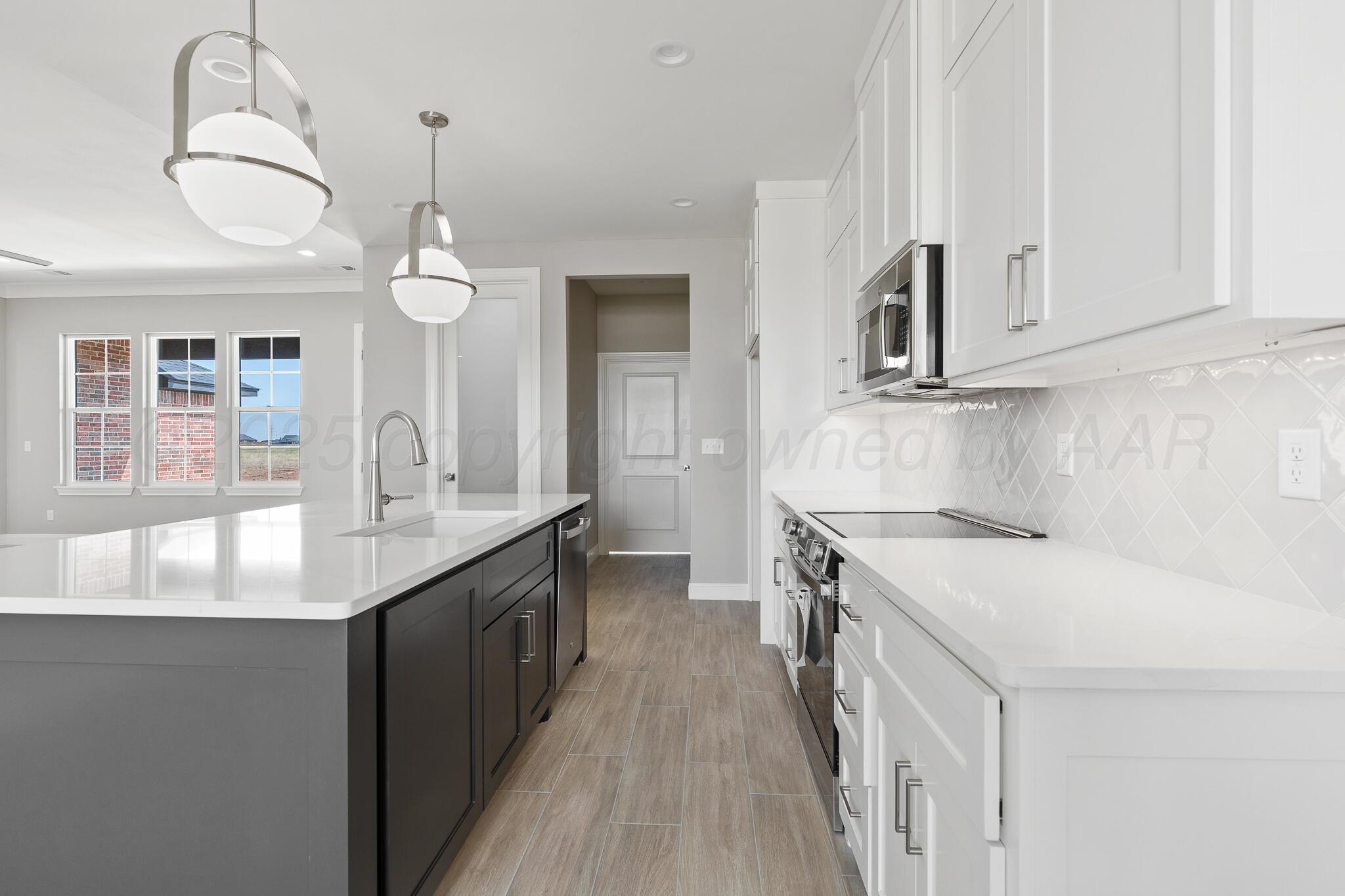 3551 Whitetail Springs Road Amarillo, TX 79119 - Photo 11 of 33 a kitchen with kitchen island granite countertop a sink a counter space and stainless steel appliances