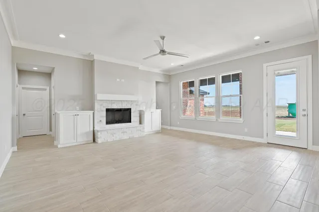 an empty room with windows and fireplace