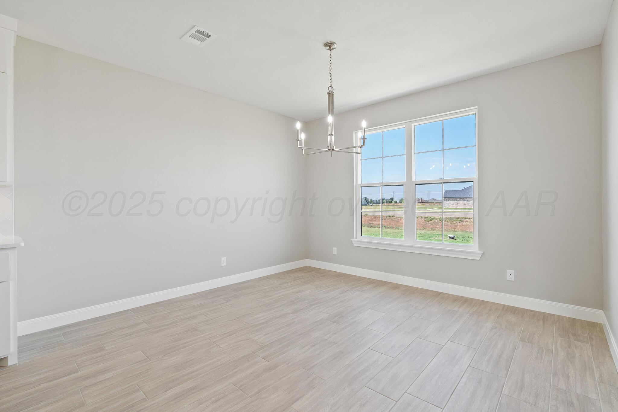 3551 Whitetail Springs Road Amarillo, TX 79119 - Photo 16 of 33 an empty room with wooden floor and windows