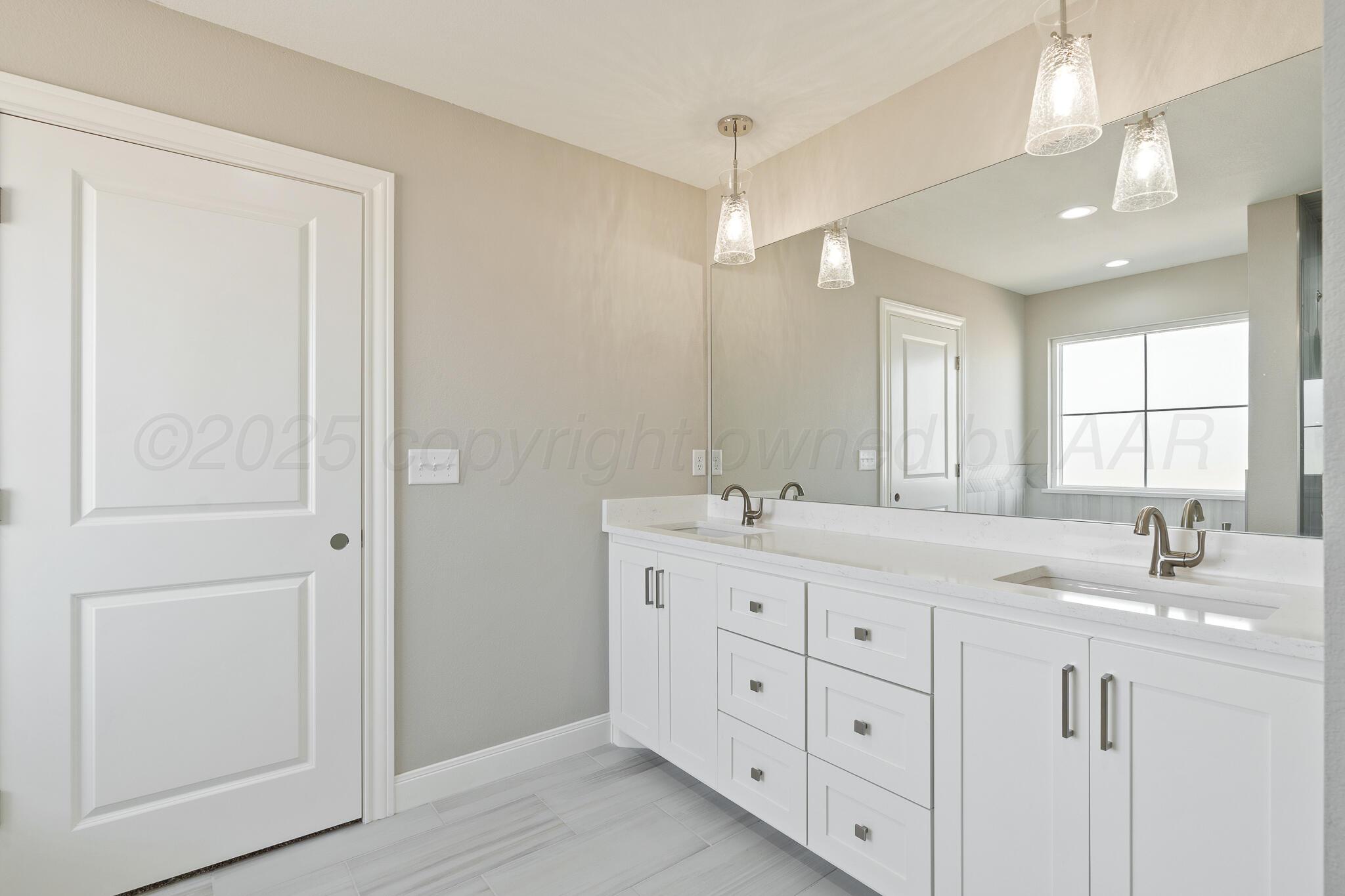 3551 Whitetail Springs Road Amarillo, TX 79119 - Photo 23 of 33 a bathroom with double vanity sink a window and a mirror