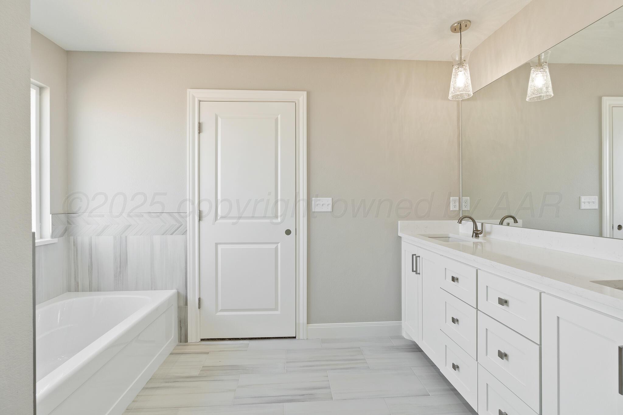3551 Whitetail Springs Road Amarillo, TX 79119 - Photo 24 of 33 a bathroom with a tub a sink and mirrors