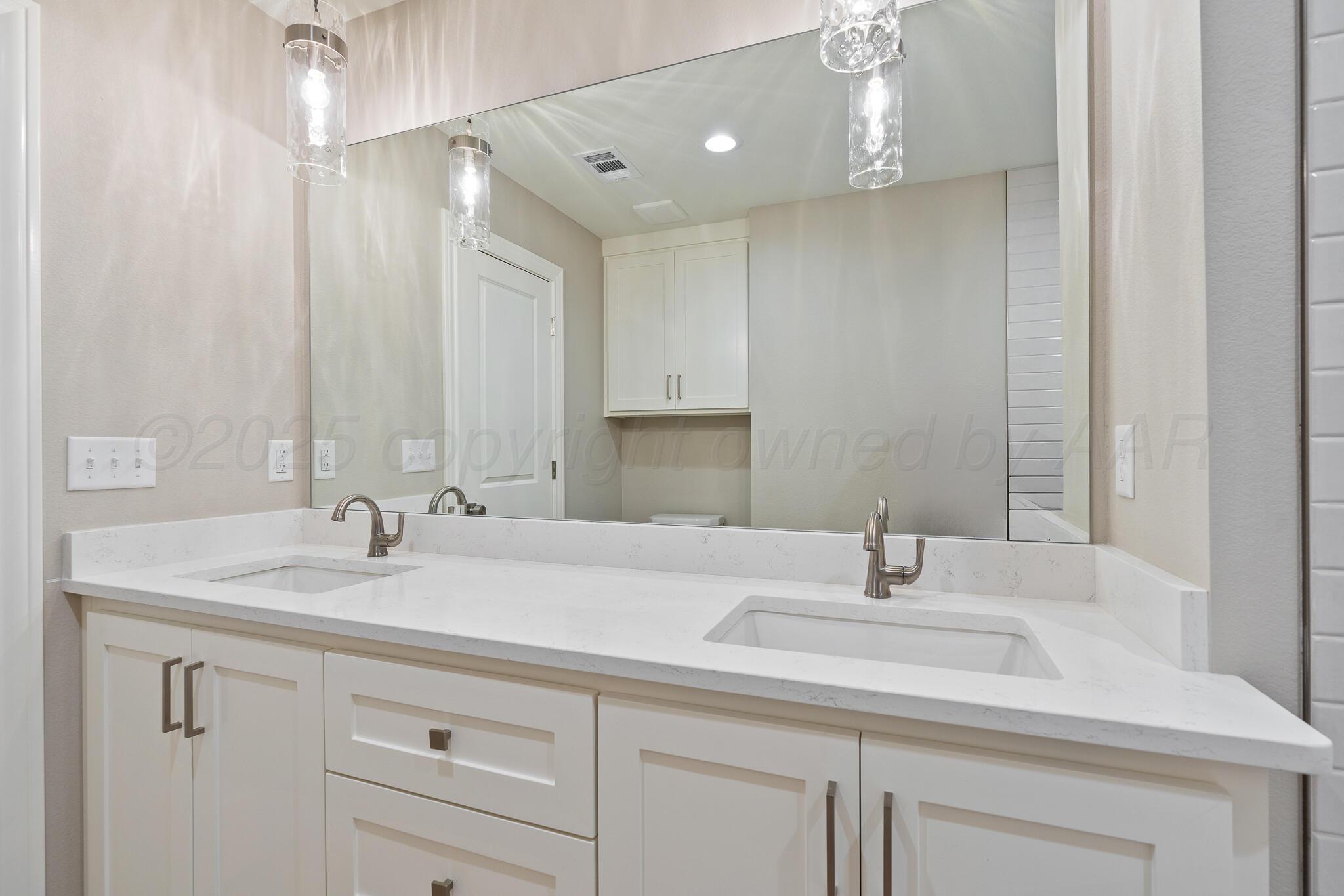 3551 Whitetail Springs Road Amarillo, TX 79119 - Photo 32 of 33 a bathroom with a sink and a mirror