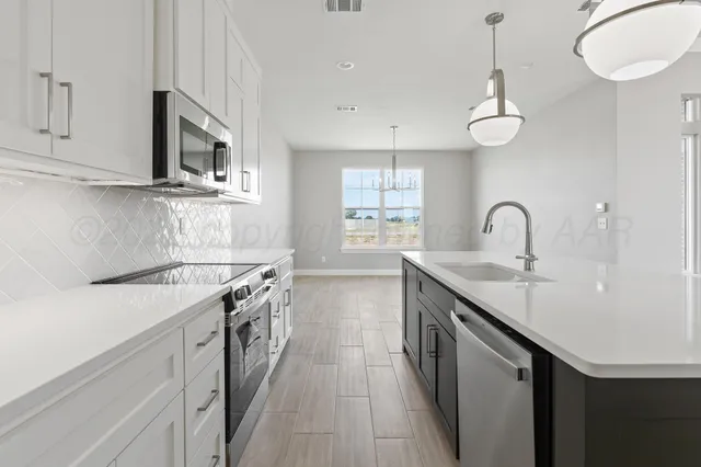 a kitchen with stainless steel appliances granite countertop a sink and dishwasher a stove top oven with wooden floor
