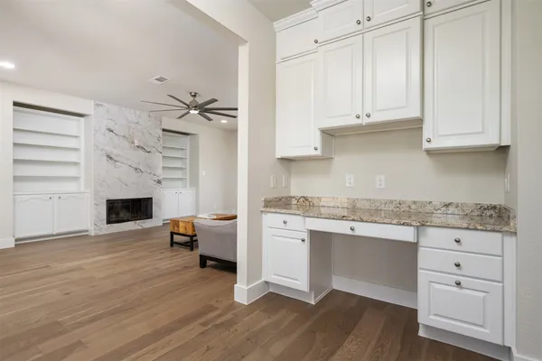 a kitchen with stainless steel appliances granite countertop a stove and white cabinets with wooden floor