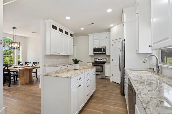 a kitchen with white cabinets and appliances