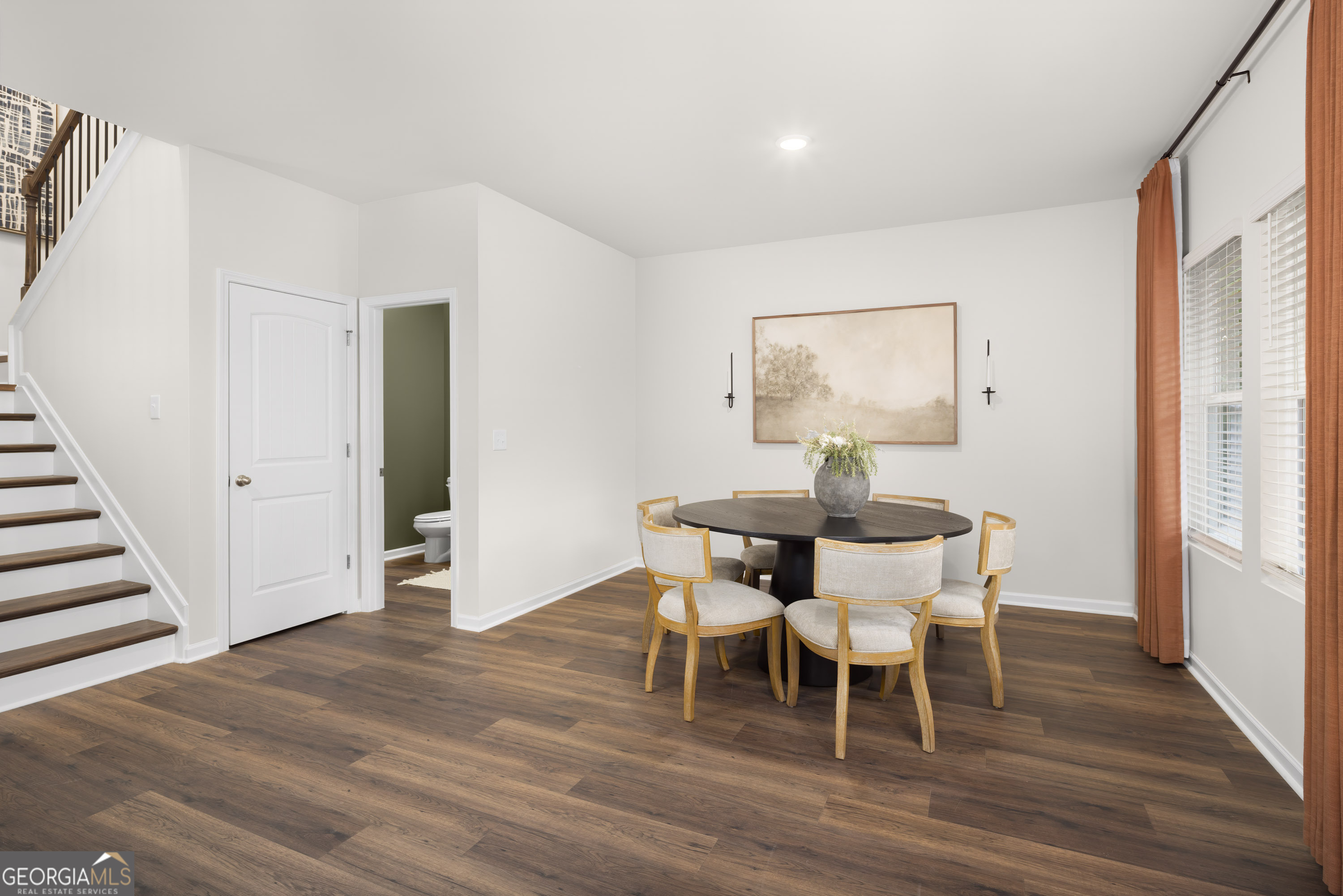 129 Southeast Honey Creek Road, Unit 4 Conyers, GA 30094 - Photo 12 of 21 a dining room with furniture a chandelier and wooden floor