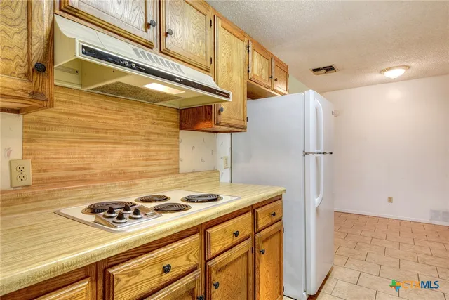 a kitchen with stainless steel appliances granite countertop a stove a refrigerator and a cabinets