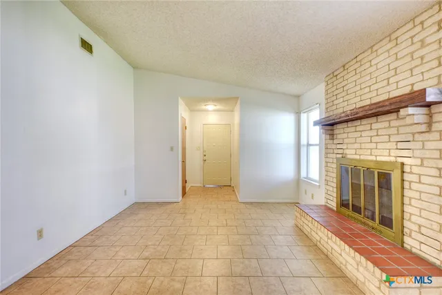 a view of a livingroom with an empty space and a fireplace