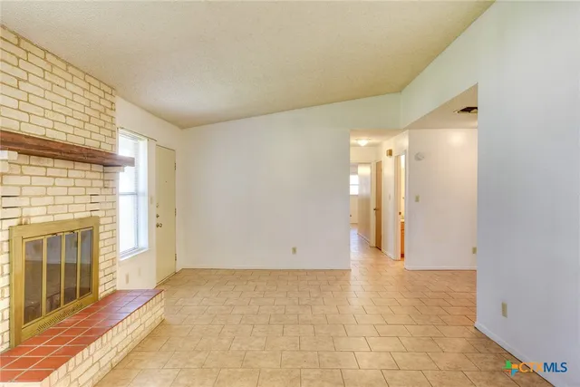 a view of a hallway with wooden floor and a fireplace