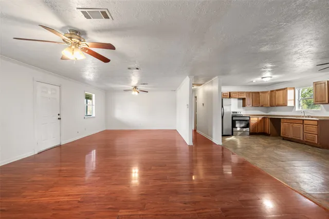 a view of an empty room with wooden floor