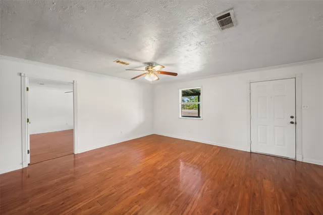 a view of empty room with wooden floor