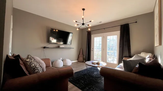 a living room with furniture a flat screen tv and a large window