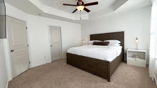 a bedroom with a bed and a ceiling fan