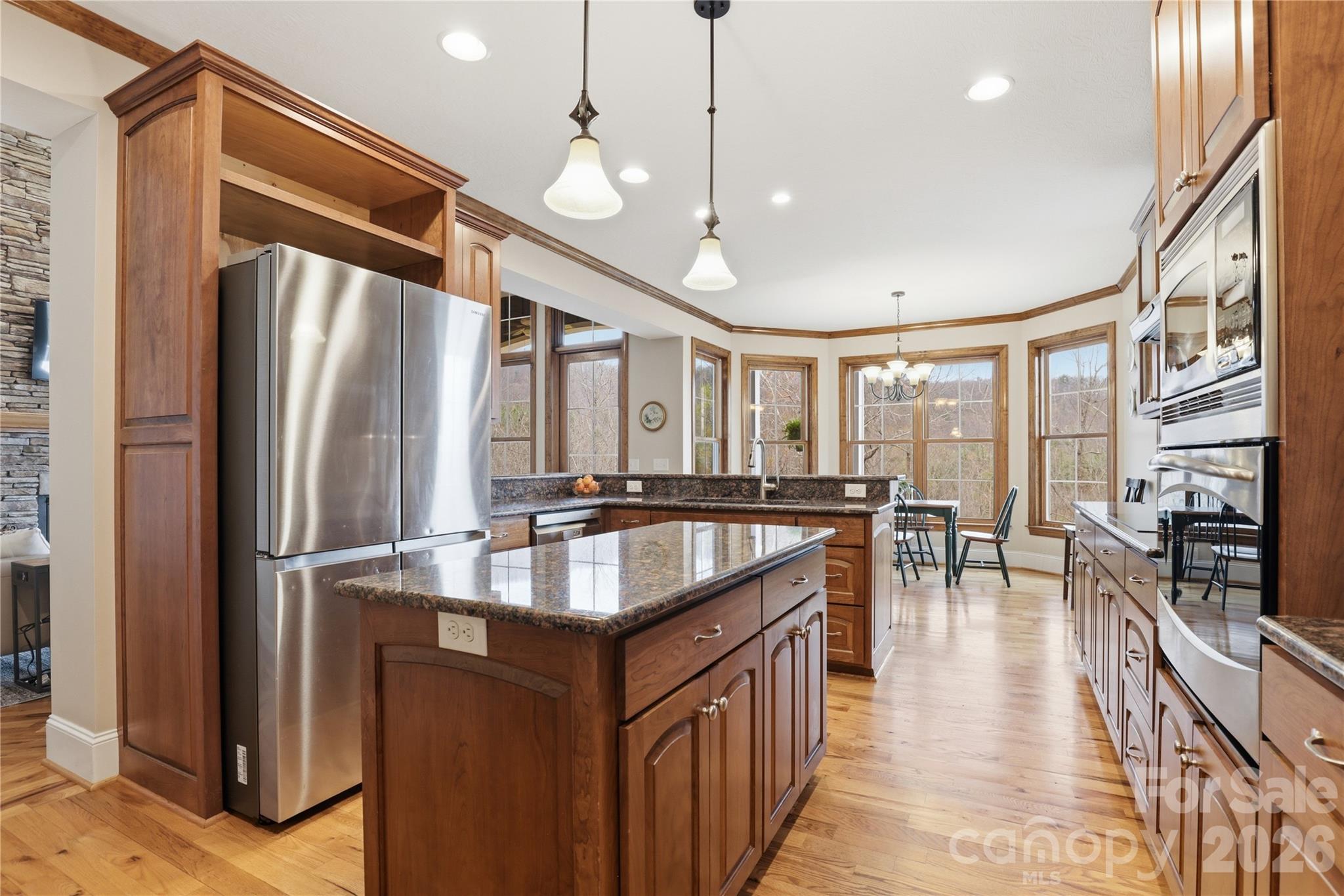 1084 Rocky Headwaters Road Moravian Falls, NC 28654 - Photo 12 of 43 a kitchen with stainless steel appliances granite countertop a refrigerator a stove and a sink with wooden floor