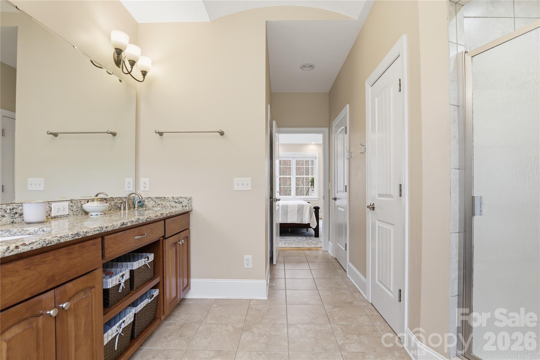 1084 Rocky Headwaters Road Moravian Falls, NC 28654 - Photo 17 of 43 a bathroom with a granite countertop sink a mirror and a shower