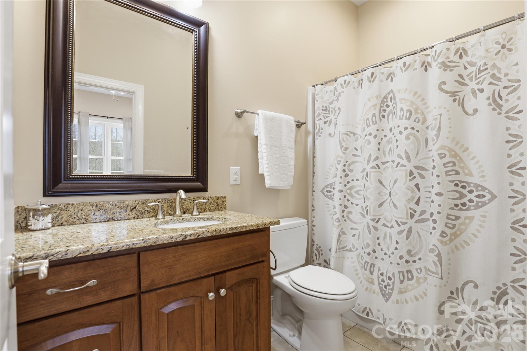 1084 Rocky Headwaters Road Moravian Falls, NC 28654 - Photo 26 of 43 a bathroom with a granite countertop toilet sink and mirror