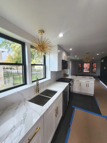 a kitchen with stainless steel appliances granite countertop a sink and a large window
