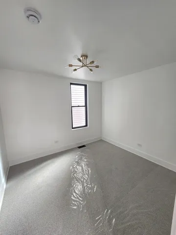 an empty room with windows and ceiling fan