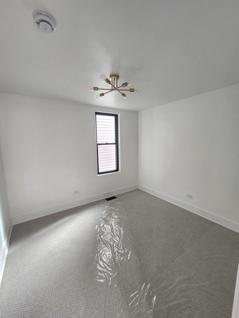 243 West Swann Street, Unit 2 Chicago, IL 60609 - Photo 5 of 10 an empty room with windows and ceiling fan