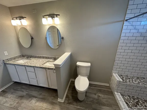 a bathroom with a toilet a sink and mirror