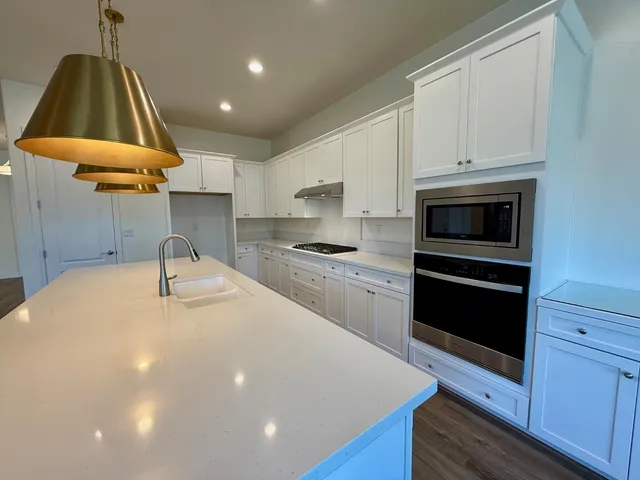 a kitchen with a sink a counter top space appliances and cabinets