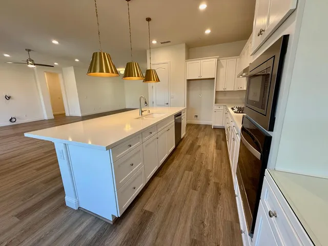 a large kitchen with a sink a refrigerator and a stove top oven