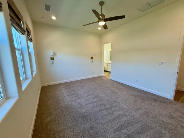 an empty room with a ceiling fan and a window