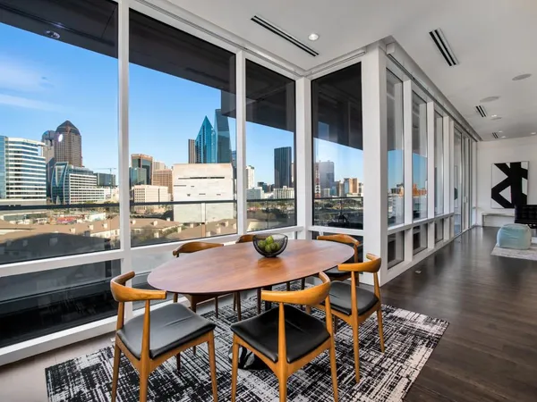 a dining room with furniture a rug and a floor to ceiling window