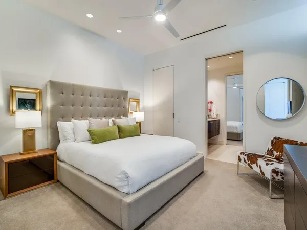 a bedroom with a bed a mirror and lamp