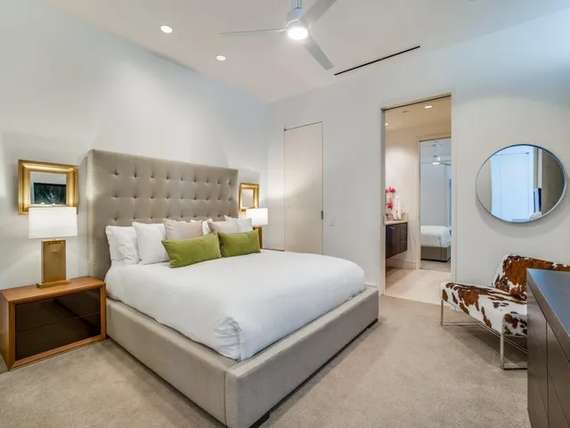 a bedroom with a bed a mirror and lamp