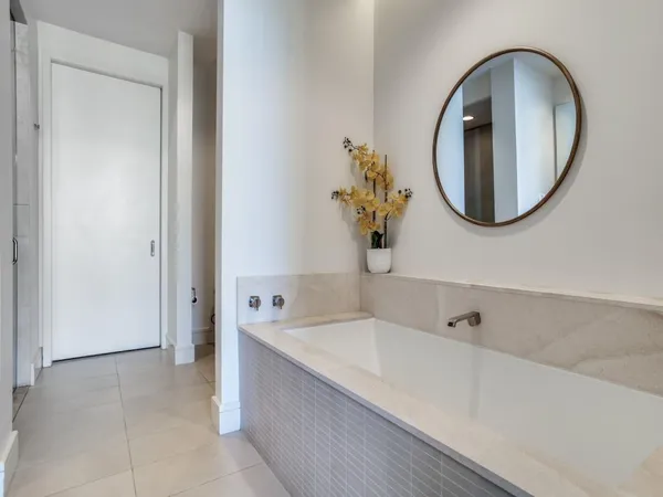 a bathroom with a tub sink and mirror