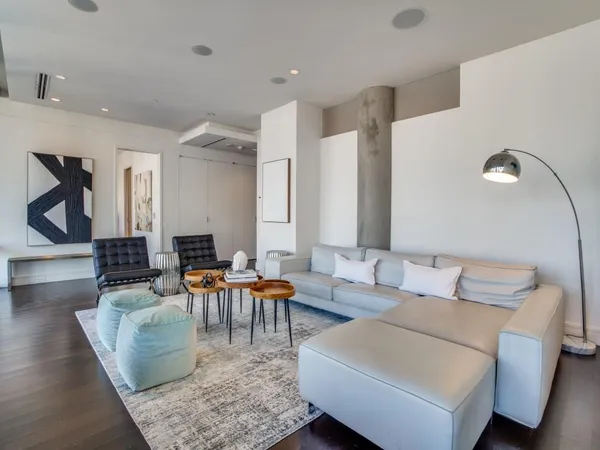 a living room with patio furniture and a rug