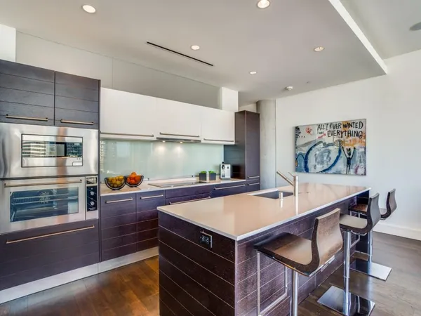 a kitchen with stainless steel appliances a stove a table and chairs