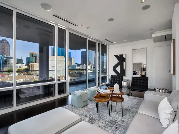 a living room with furniture a rug and a large window