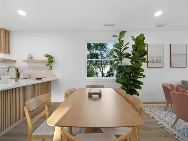 a white table with chairs and a potted plant